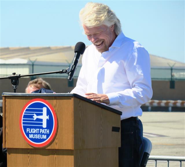 Richard Branson, Virgin group founder, stands at the podium for speech. 