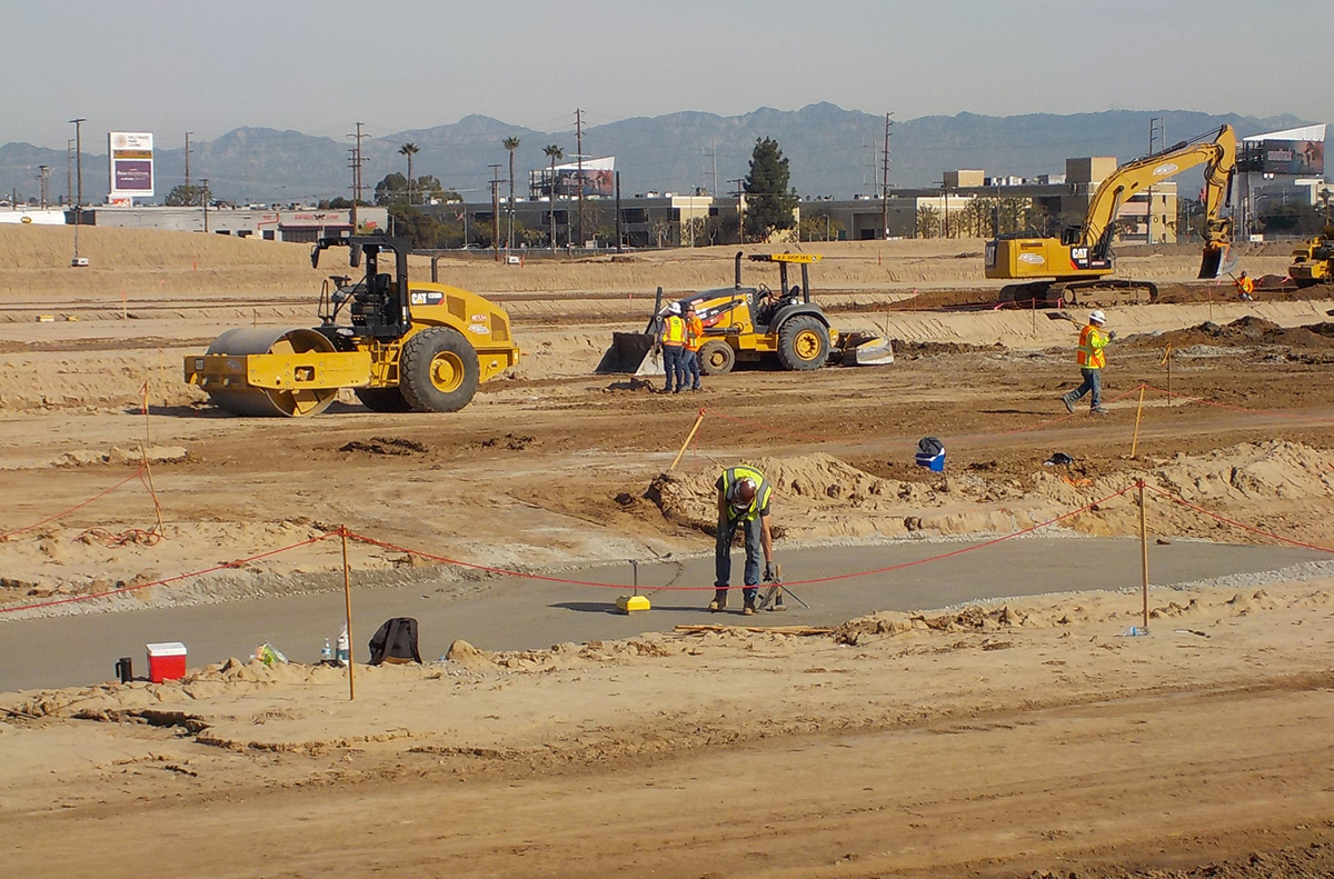 Workers installing the Crushed Miscellaneous Base (a layer put down before pouring concrete) at the Consolidated Rent-A-Car Facility site.